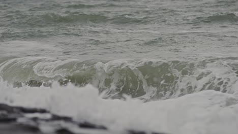 Gentle wave rolling onto a quiet beach in Domburg, Zeeland, Netherlands in slow motion