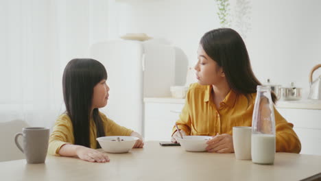 어머니 와 딸 이 함께 아침 식사를 즐기고 있다