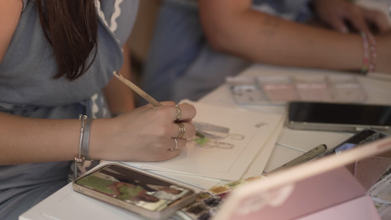 Close up of artist painting couple sketch using watercolors
