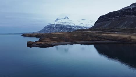 Verschneite-Felsige-Berge-Am-Meer-An-Einem-Wintertag