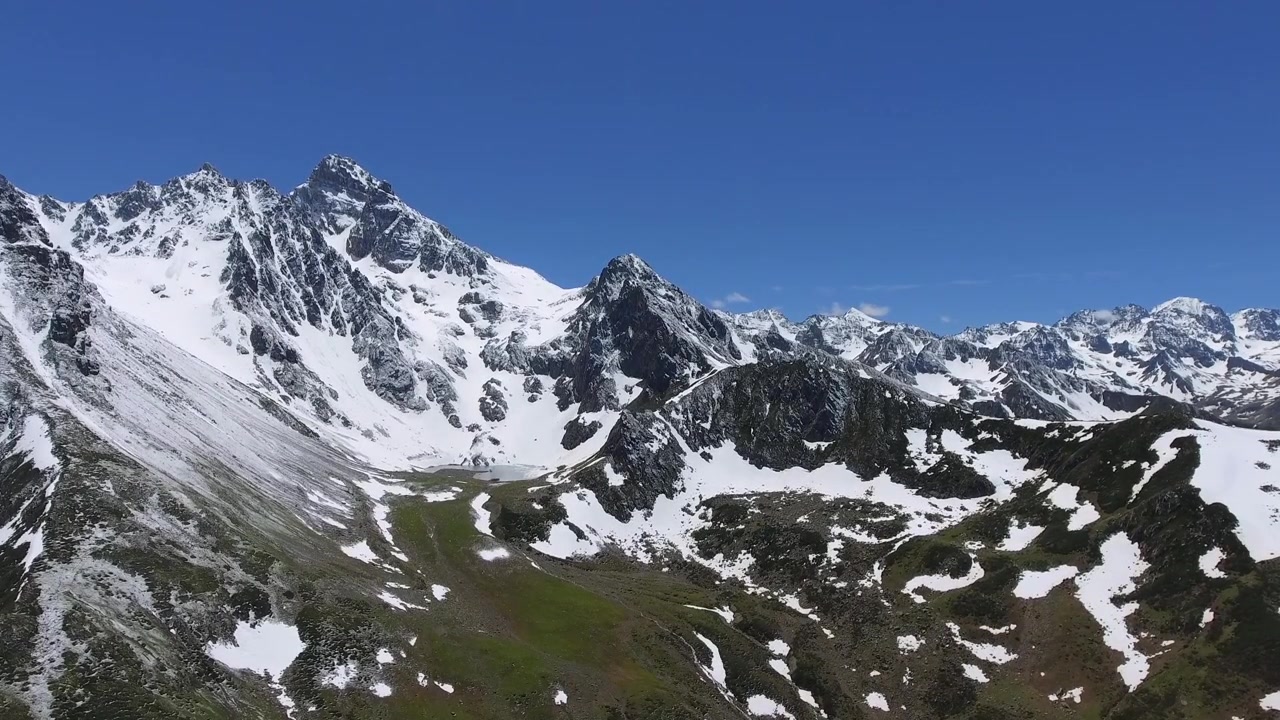 Majestætiske sneklædte bjergtoppe under klar blå himmel