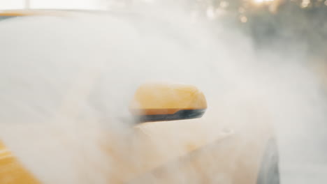 coche descapotable amarillo siendo lavado