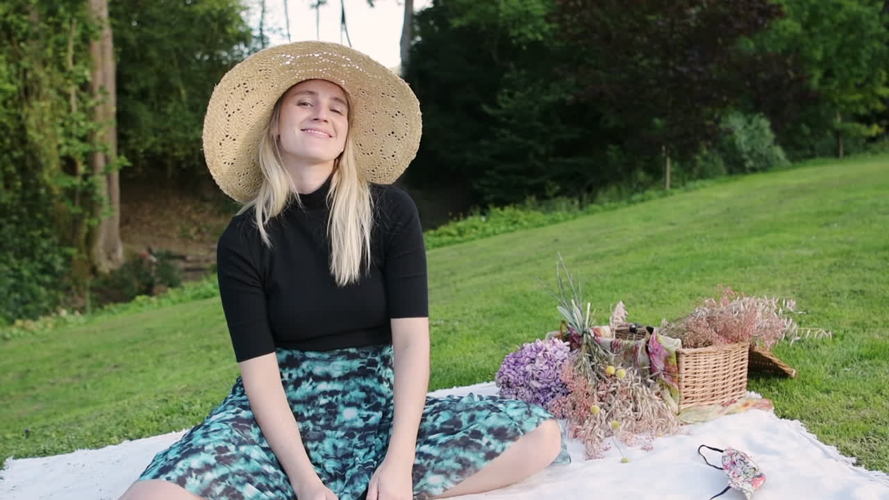 Cute young woman smiling out of pure happiness at a picnic in a park
