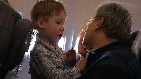 Niño-Explorando-La-Cara-Del-Abuelo-En-El-Avión