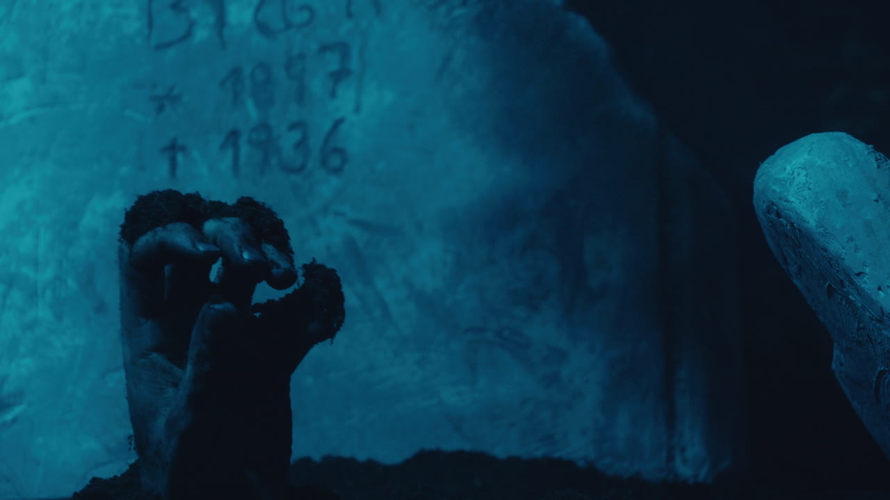 mano levantándose de la tumba a la luz de la luna azul, lápida en el fondo, atmósfera de terror de halloween