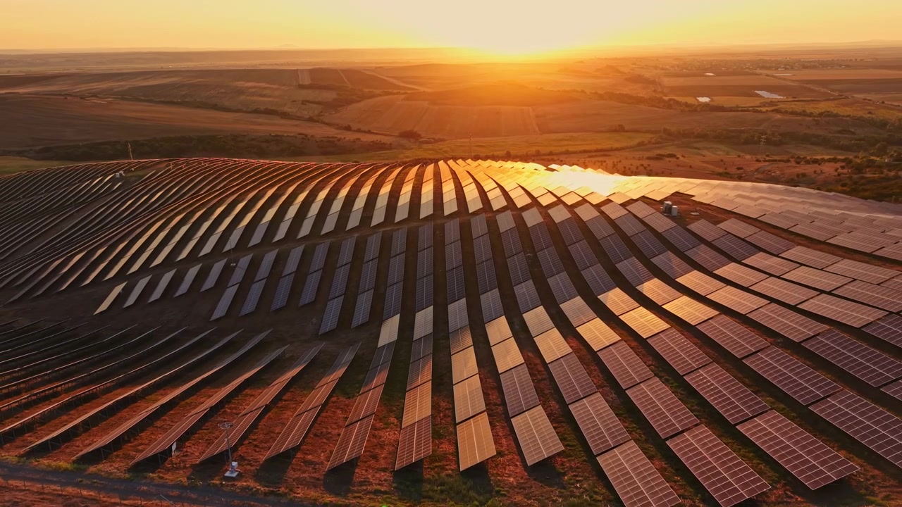 Solpaneler fanger sollys ved solnedgang på en stor energipark på landet