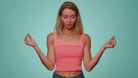 woman breathes deeply with mudra gesture, eyes closed meditating with concentrated thoughts peaceful