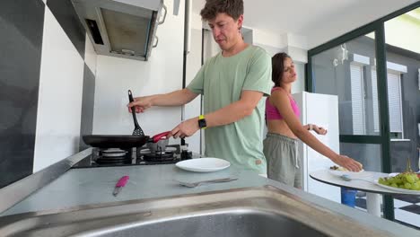 una pareja joven cocinando en la cocina.