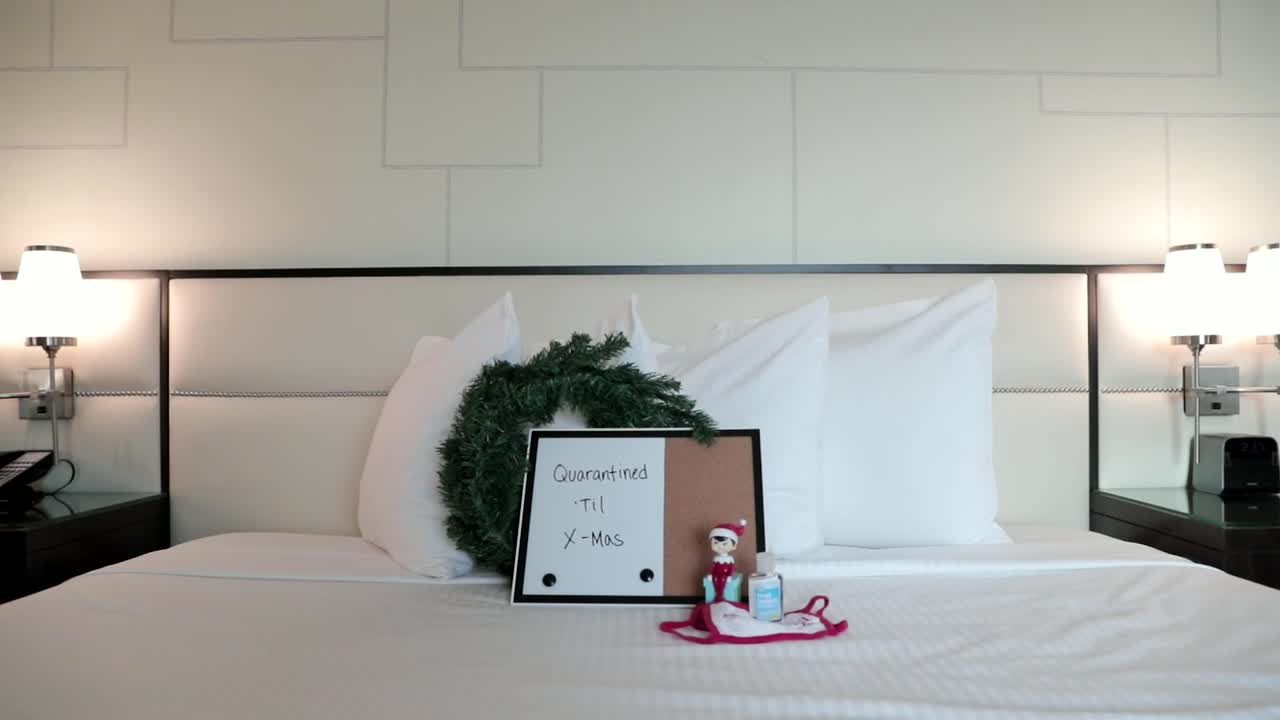 Quarantined Until X-Mas Sign on hotel room bed