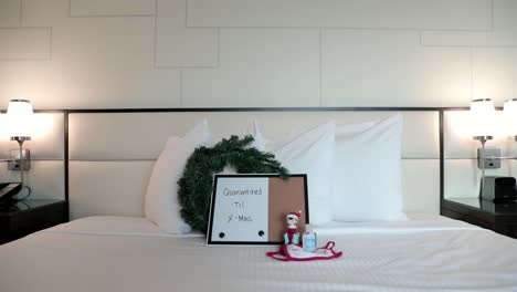 quarantined until x-mas sign on hotel room bed
