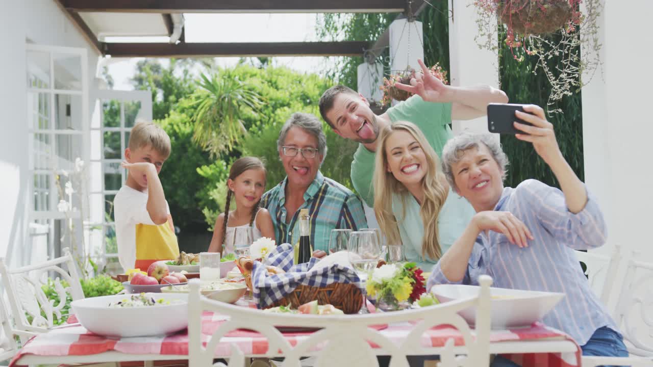 Glad familie spiser sammen ved bordet
