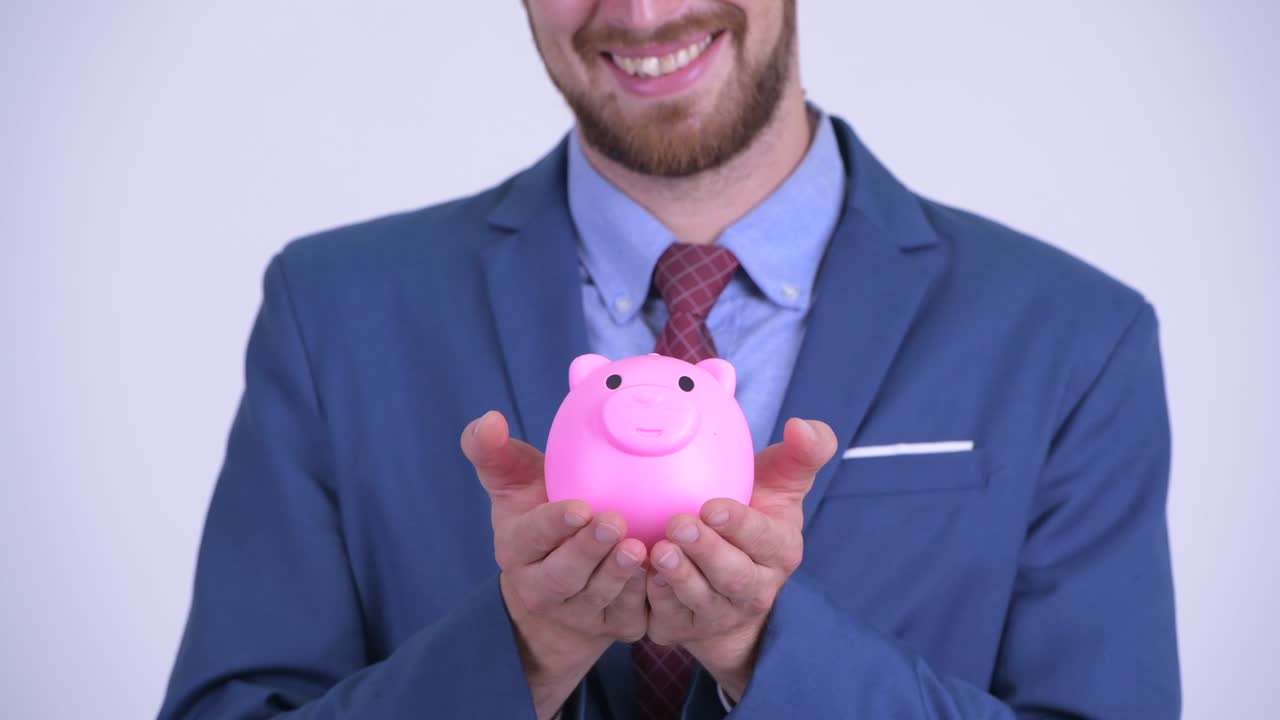 retrato de un feliz hombre de negocios barbudo con una alcancía
