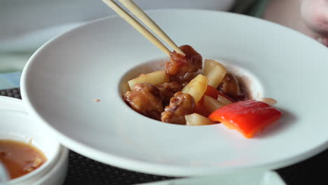 Fried-chicken-in-sweet-and-sour-sauce-with-pinnacles-and-red-peppers-at-restaurant-shot-at-30-fps