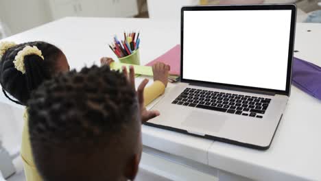 composition of african american schoolgirl and schoolboy on laptop online learning with blank screen
