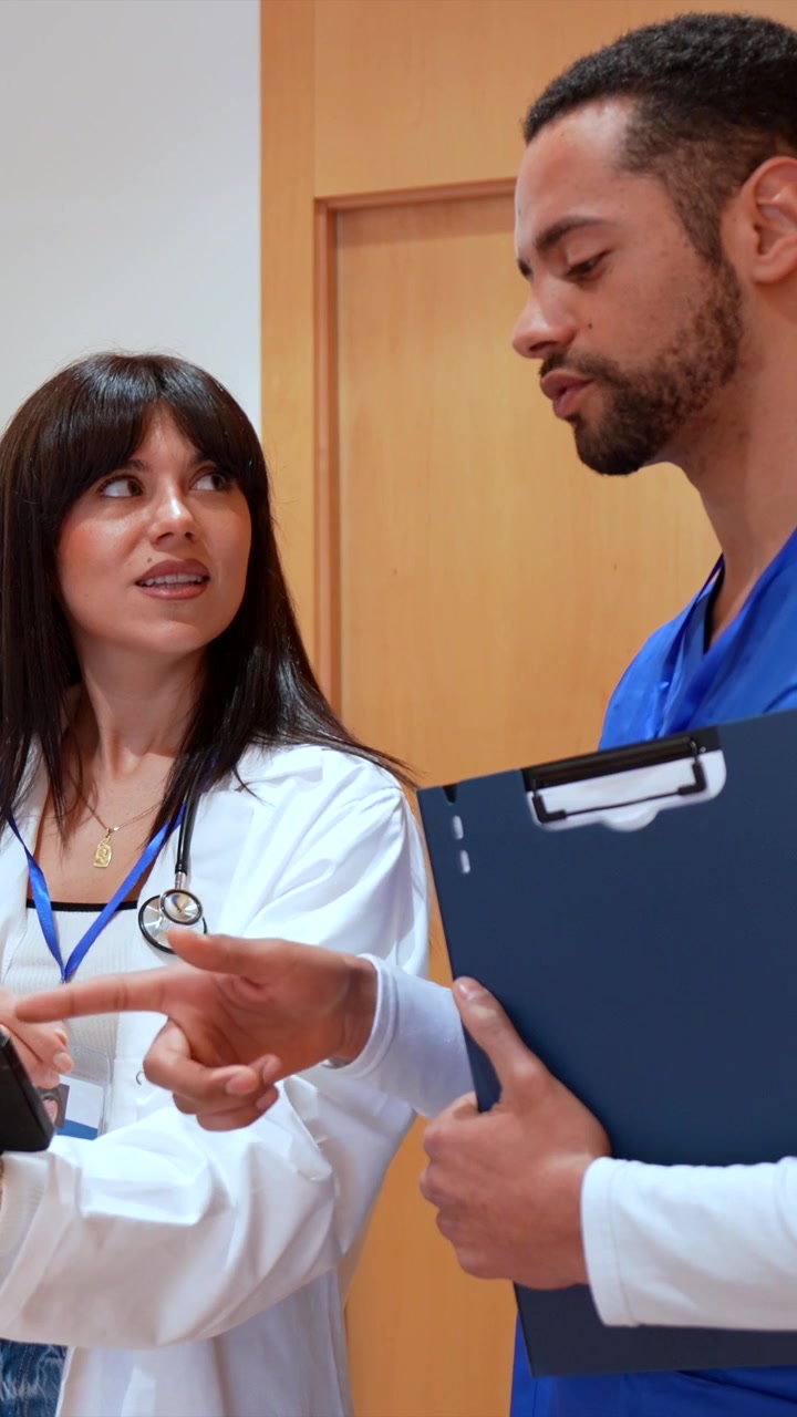 Professionisti medici che discutono i dati dei pazienti su tablet in ospedale