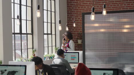 young-african-american-business-woman-using-smartphone-making-phone-call-talking-on-mobile-phone-conversation-discussing-professional-ideas-in-modern-startup-office