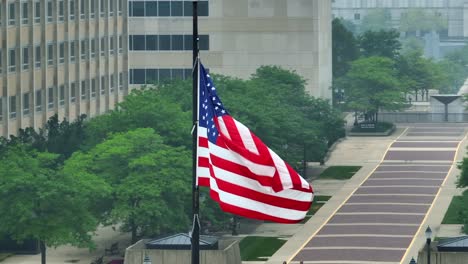 American-flag-waving-in-front-of-government-complex-with-many-buildings