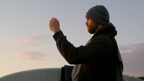 Vista-Lateral-De-Un-Hombre-Caucásico-De-Mediana-Edad-Haciendo-Clic-En-La-Foto-Con-Un-Teléfono-Móvil-Cerca-De-La-Playa-4k