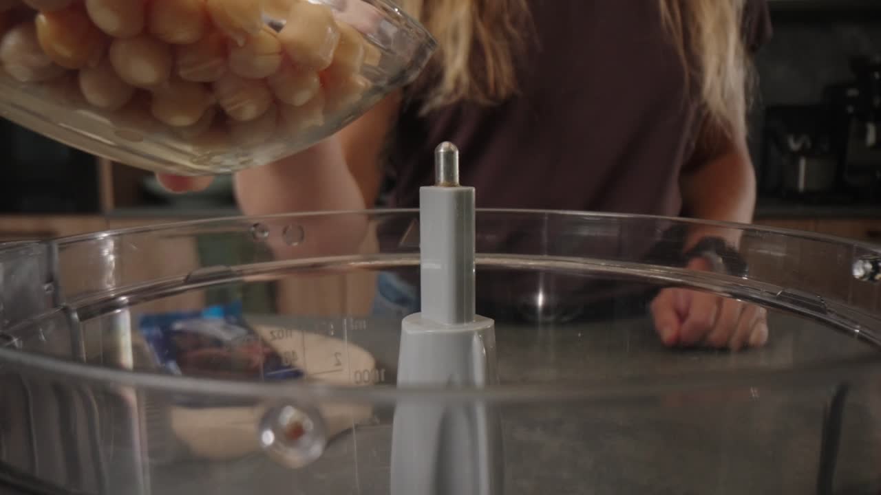 Dropping chickpeas from bowl into blender for healthy recipe, macro probe lens