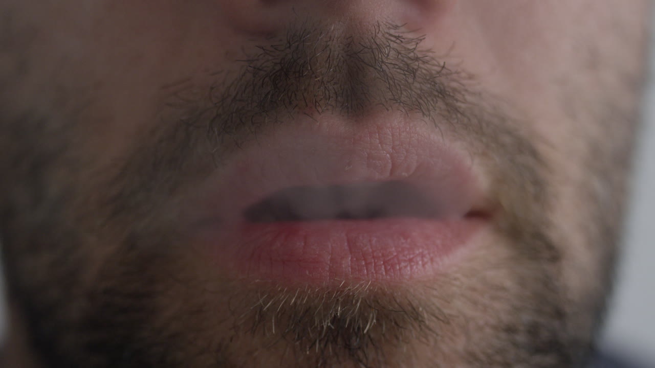 un hombre que usa una pluma de vape que inhala cannabis con nicotina o cbd con sabor