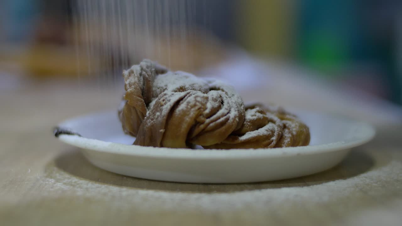 panadero espolvorear azúcar en polvo y chocolate en la parte superior de las galletas, pasteles de comida y panadería
