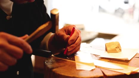 close-up of hands carving wood with chisel