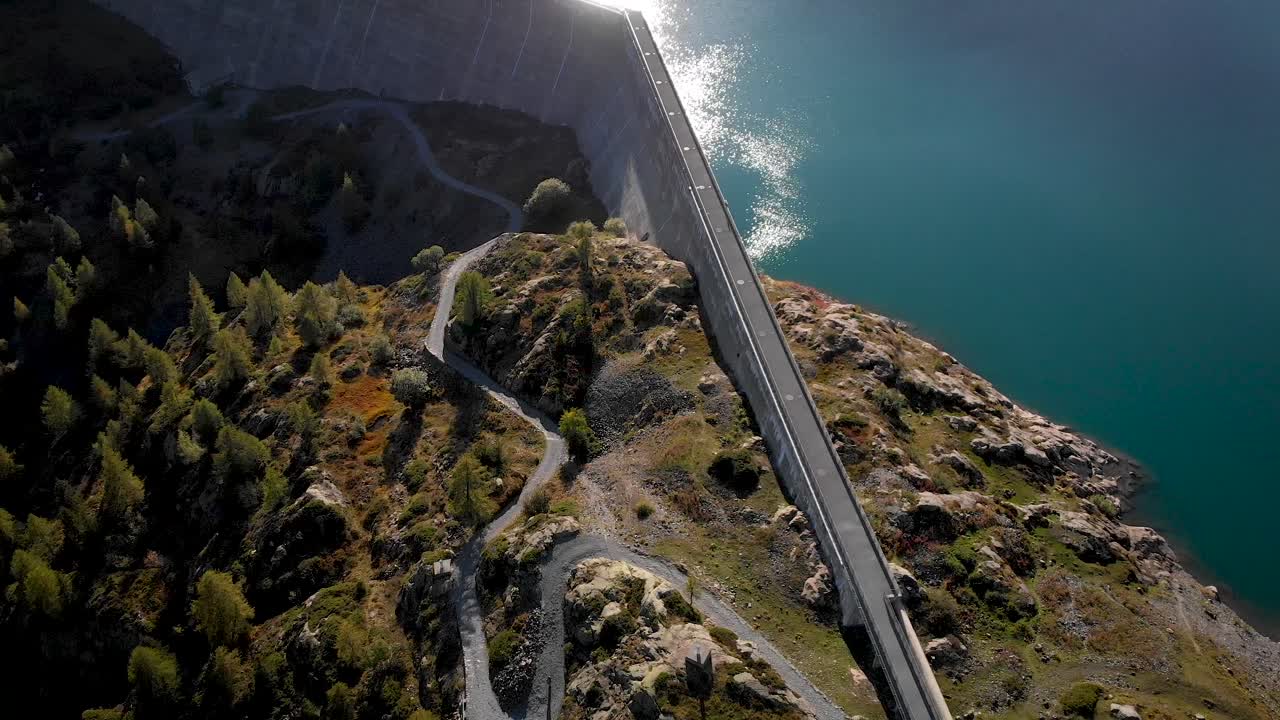 Aerial flyover over the hydroelectric dam of Lac de Salanfe in Valais, Switzerland on a sunny autumn day in the Swiss Alps in a remote alpine location