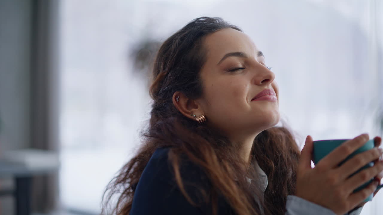 Dreamy woman smiling happily indoors portrait. Happy manger taking coffee cup