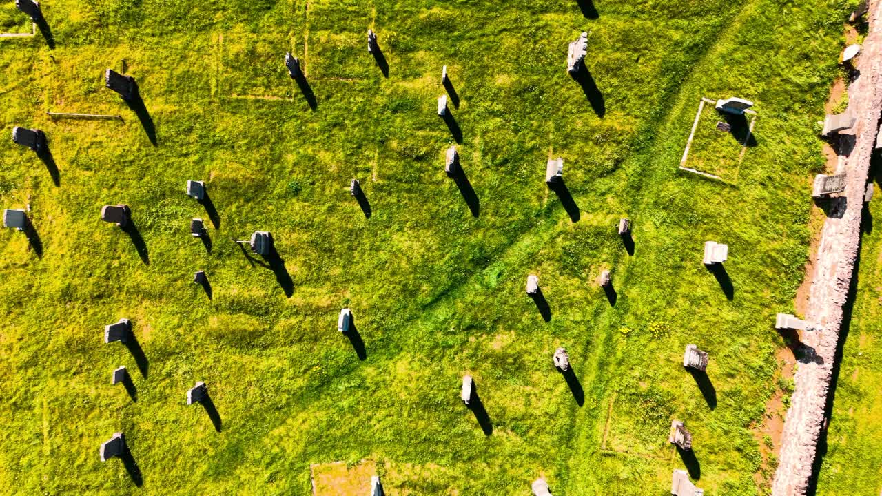 Aerial view of a graveyard with gravestones and green grass