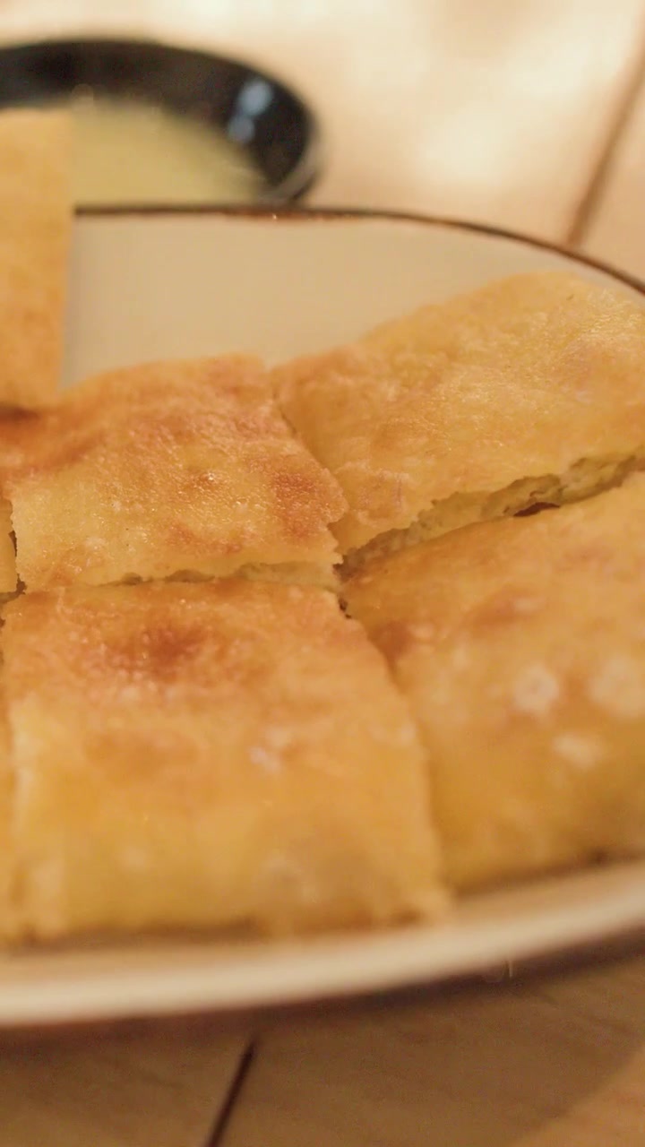 Primo piano di un pancake roti fritto croccante a fette su un piatto a Bangkok, Thailandia.