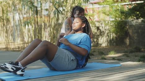 Long-shot-of-girl-cheering-her-friend-who-exercising-abs