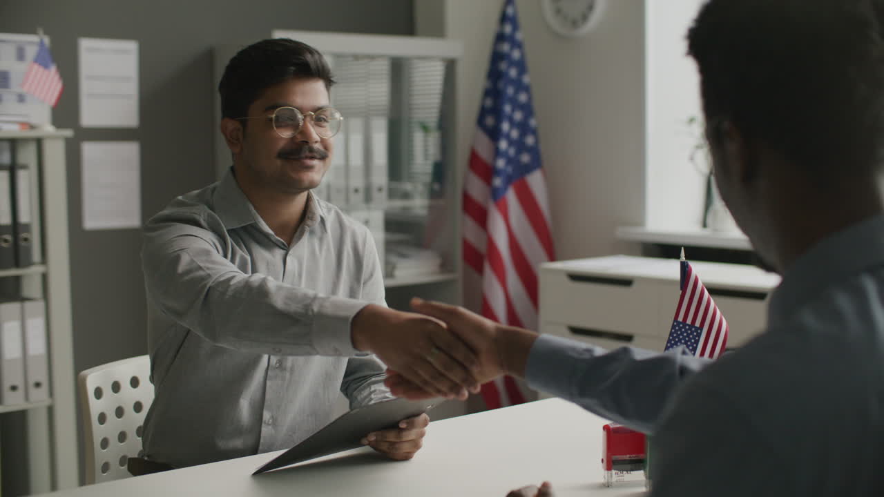 Immigration Officer Shaking Hand of Indian Man after US Visa Approval