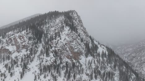 aerial footage of snow-covered rocky mountain cliffs in colorado winter.