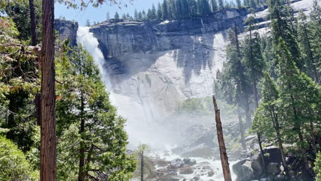 un hombre toma una fotografía de la cascada brumosa en el parque nacional de yosemite