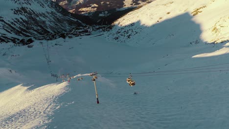 Góndola-De-Telesilla-De-Estación-De-Esquí-En-Pistas-De-Esquí-De-Montaña-Empinadas,-Vista-Aérea-De-La-Puesta-De-Sol