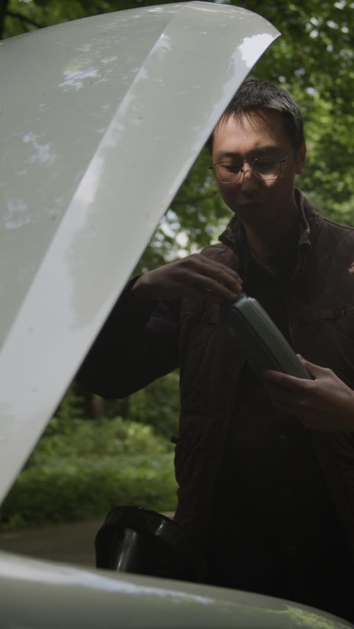 Man Adding Oil to Car Engine
