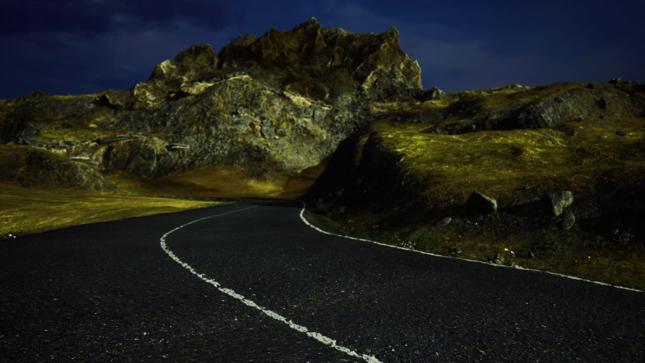 Winding road through rocky terrain under night sky with soft lighting