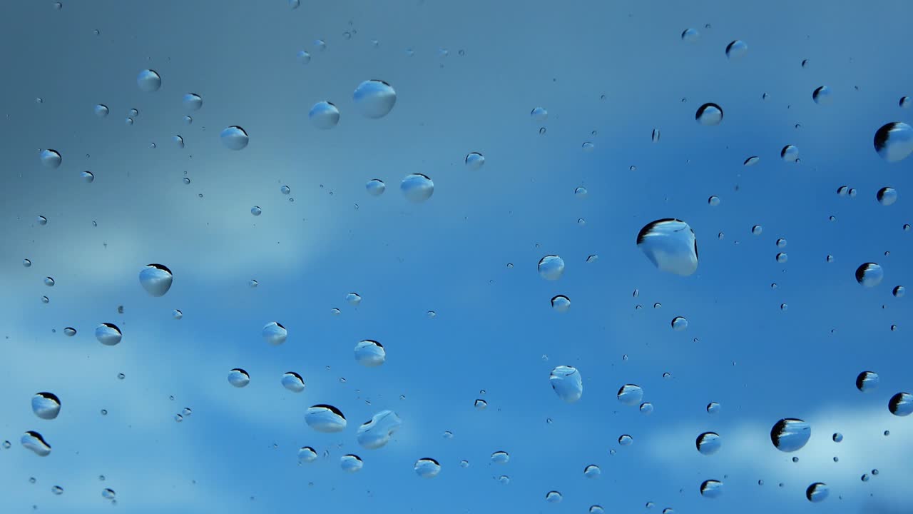 vista de cerca de las gotas de lluvia que caen sobre una superficie de vidrio