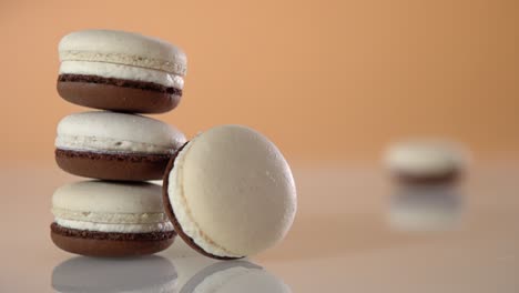 a macaroon slides across a surface past a stack of macaroons