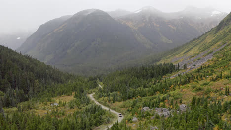 Valley-trail-in-scenic-mountains-of-British-Columbia-with-car-driving,-aerial