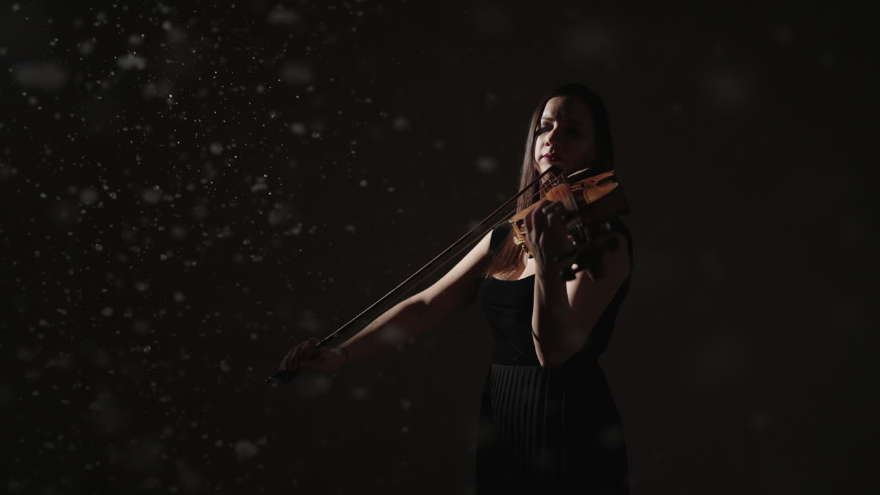 violinista en un estudio oscuro con efecto de nieve