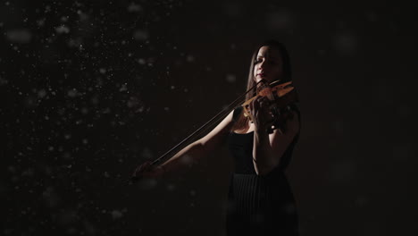 violinist in a dark studio with snow effect