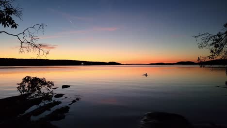 Un-Turista-Rema-En-El-Océano-Al-Atardecer-Con-Una-Impresionante-Vista-Panorámica-Del-Colorido-Crepúsculo,-Hora-Dorada-Del-Atardecer-En-La-Costa-Noroeste-Del-Pacífico-De-Canadá