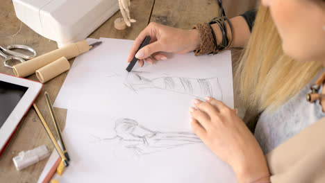 Crop-shot-of-dressmaker-drawing-sketches