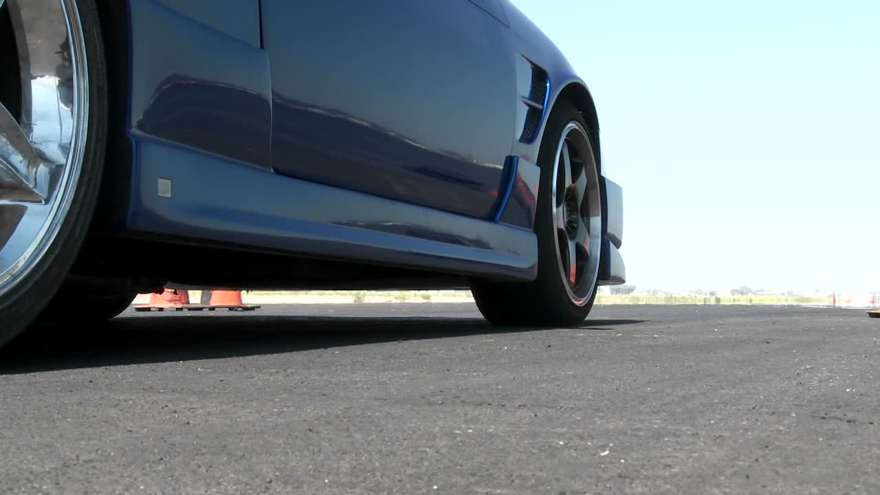 캘리포니아 카마릴로의 드리프트 코스에서 이륙하기 전에 파란색 자동차가 엔진을 회전시킵니다.