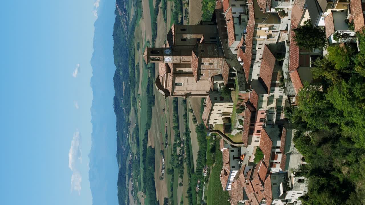 vista aérea de la torre del reloj de la iglesia parroquial en la ladera de ozzano monferrato, italia