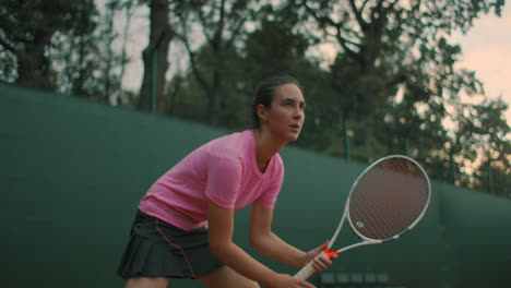 Eine-Junge-Frau-Trainiert-Bei-Sonnenuntergang-Auf-Einem-Hartplatz-Tennisplatz-Die-Bereitschaftsposition.