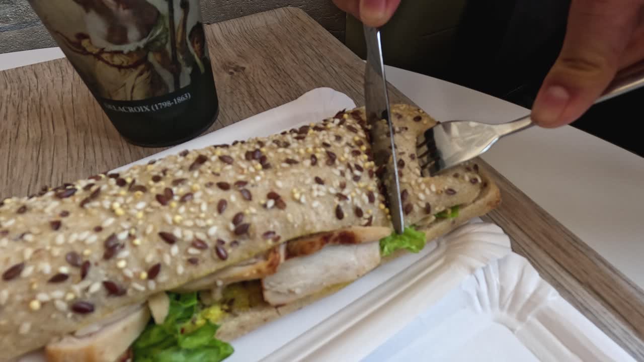 persona cortando sándwich con cuchillo y tenedor