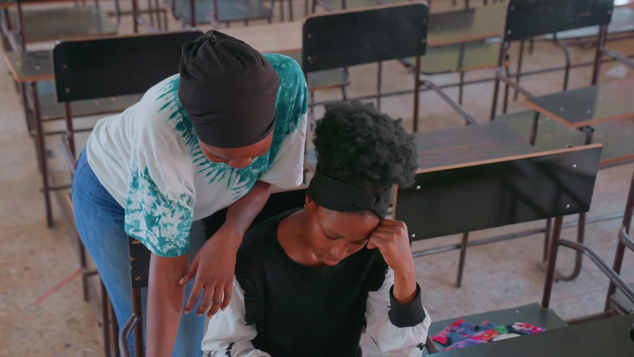 Gentle mom guides student patiently. Warm light illuminates thoughtful moment in learning environment. Caring mother offers comfort and mentorship to her attentive child in classroom setting