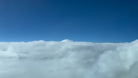 piloto aéreo volando sobre nubes blancas tormentosas con un cielo azul profundo